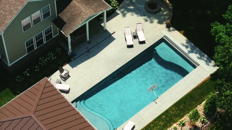 Top-down view of the pool deck, loungers and fire pit