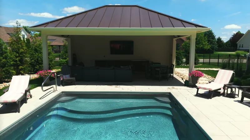 Pool house with lounge seating, dining table and wall-mounted TV